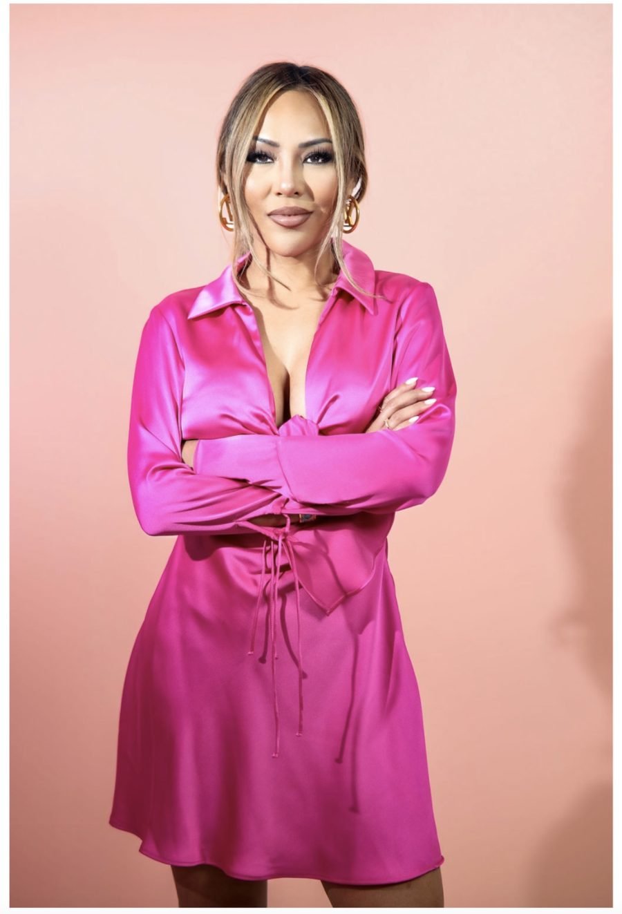 Lucy Wo, founder of WOAH Lash, in magenta satin against a blush background